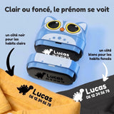 Le tampon recto-verso Étiquette Magique : un côté noir pour marquer le prénom Lucas sur un tee-shirt jaune clair, un côté blanc pour le marquer sur un tee-shirt foncé