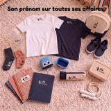 Toutes les affaires de Léa marquées à son prénom avec le tampon Étiquette Magique : tee-shirts clair et foncé, sac à dos, chaussures, chaussettes, gourde, boîte à goûter, trousse, cahiers et corde à sauter